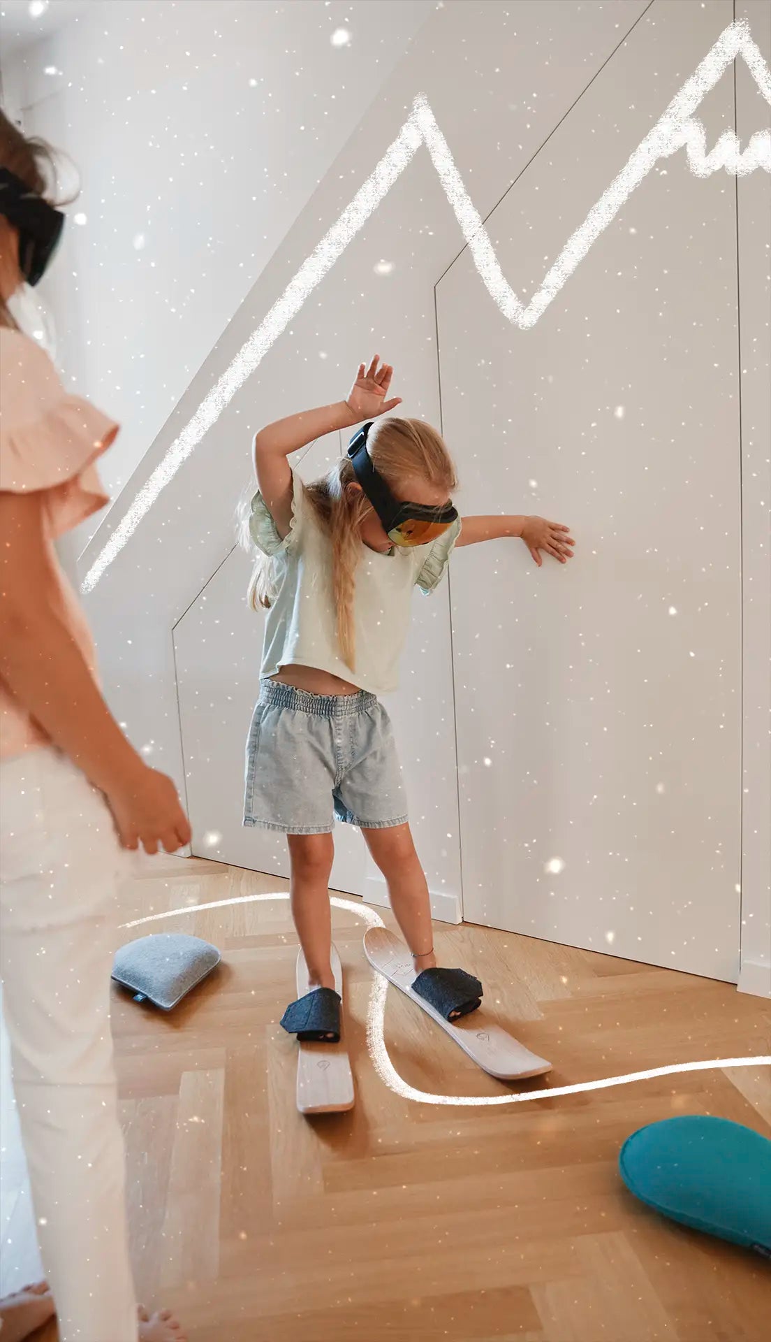 Girl in ski goggles practising on drySki kids' skis in the playroom – learning to ski at home